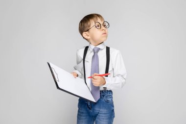 sevimli çocuk tutan bir kalem ve notlar için yaprak