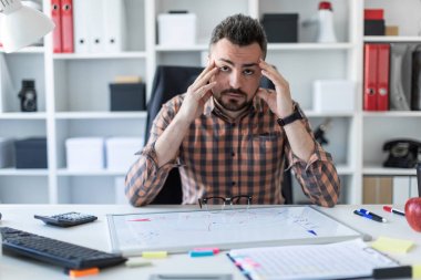 Bir adam ofiste bir masada oturuyor.