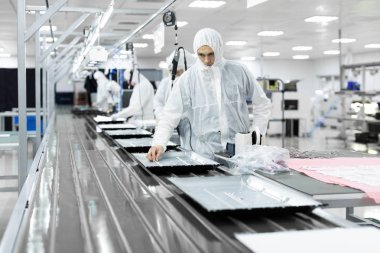 işçiler atölyede TV test beyaz üniformalı. Elektronik montaj hattı