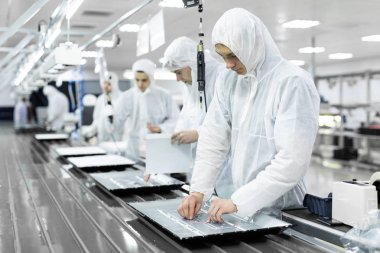 işçiler atölyede TV test beyaz üniformalı. Elektronik montaj hattı
