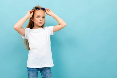 Mavi arka planda poz veren tatlı küçük kız. 