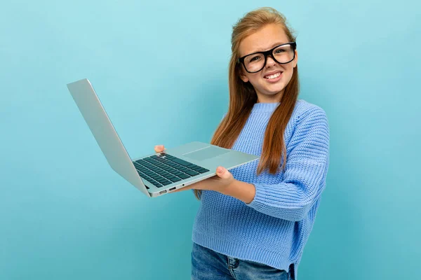 Mavi Arka Planda Gözlük Dizüstü Bilgisayarla Poz Veren Küçük Kız — Stok fotoğraf