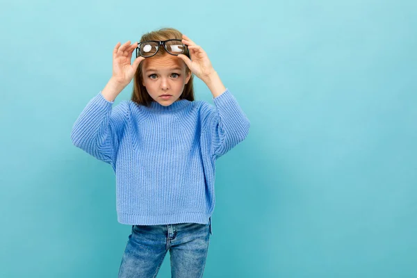 Mavi Arka Planda Gözlüklerle Poz Veren Küçük Akıllı Kız — Stok fotoğraf