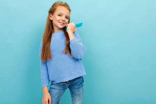 Mavi Arka Planda Saç Fırçasıyla Poz Veren Küçük Kız — Stok fotoğraf