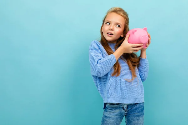 Niña Con Alcancía Contra Fondo Azul —  Fotos de Stock