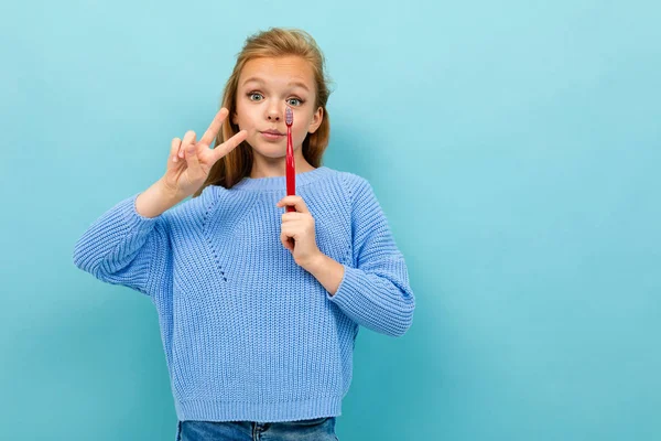 Mavi Arka Planda Diş Fırçasıyla Poz Veren Küçük Kız — Stok fotoğraf