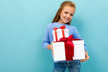 Mavi arka planda iki hediyeyle poz veren küçük kız 