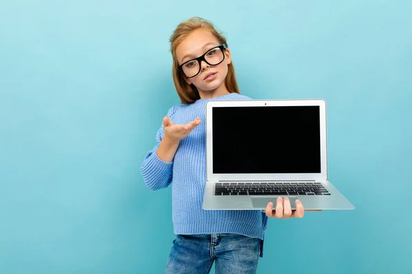 Mavi Arka Planda Gözlük Dizüstü Bilgisayarla Poz Veren Küçük Kız — Stok fotoğraf