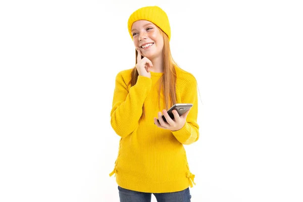 穿着黄色衣服的可爱女孩 背景为白色 摆出手机的姿势 — 图库照片