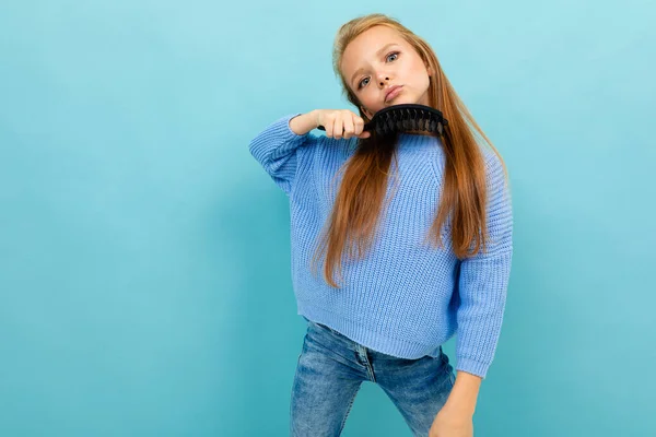 Niña Posando Con Cepillo Pelo Sobre Fondo Azul —  Fotos de Stock