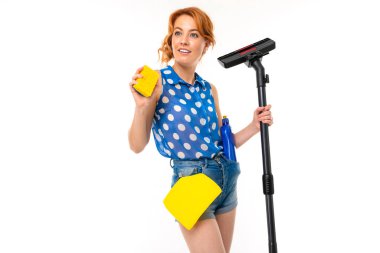 Genç kızıl saçlı kadın elektrik süpürgesi beyaz arka planda poz veriyor.  