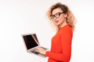 young woman in red dress posing with laptop against white background  