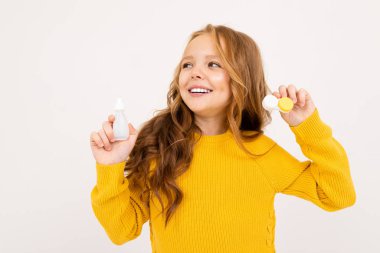 Stüdyoda göz damlalarıyla poz veren tatlı bir kız. 