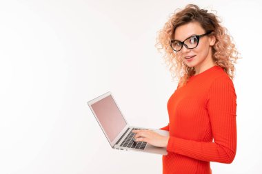 young woman in red dress posing with laptop against white background  