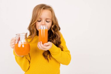 Stüdyoda hafif arka planda meyve suyu ile poz veren tatlı kız. 
