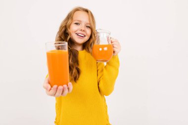 Stüdyoda hafif arka planda meyve suyu ile poz veren tatlı kız. 