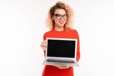 young woman in red dress posing with laptop against white background  
