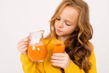 Stüdyoda hafif arka planda meyve suyu ile poz veren tatlı kız. 