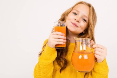 Stüdyoda hafif arka planda meyve suyu ile poz veren tatlı kız. 