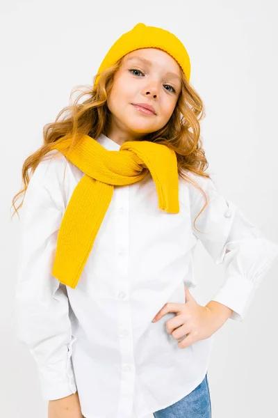 时髦可爱的小女孩头戴黄色的帽子和围巾在浅色背景下摆姿势的肖像 — 图库照片