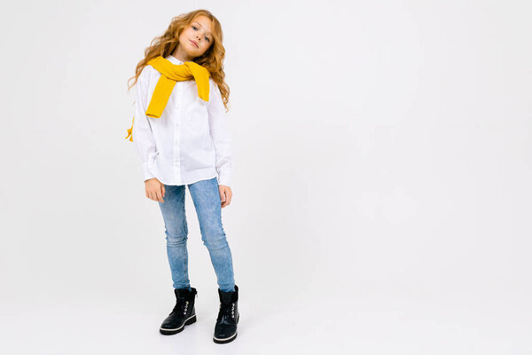 fashionable schoolgirl posing in studio on light background 