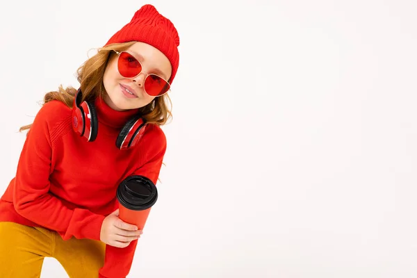 Милая Девушка Красных Очках Позирует Наушниках Держит Бумажную Чашку Студии — стоковое фото
