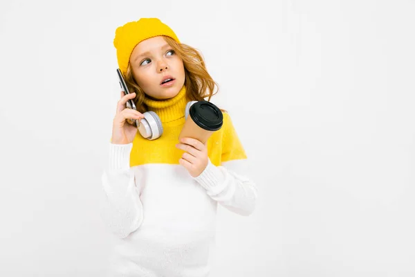 Cute Little Girl Słuchawki Pozowanie Papierowym Kubkiem Telefon Komórkowy Studio — Zdjęcie stockowe