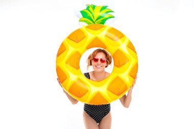 Güneş gözlüklü genç kadın beyaz arka planda lastik yüzükle poz veriyor.  