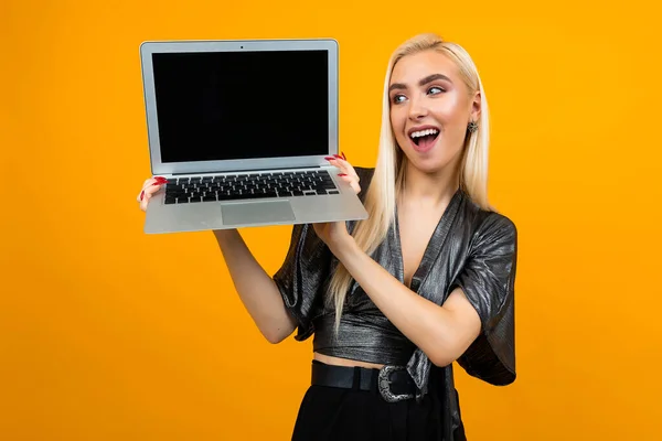 Fată europeană care deține laptop cu ecran gol pentru pagina web pe fundal galben — Fotografie, imagine de stoc