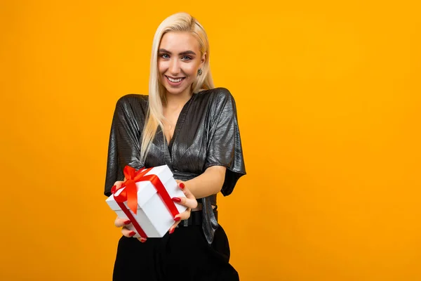 Boldog vonzó lány tartja ki ajándék doboz sárga háttér másolási hely — Stock Fotó