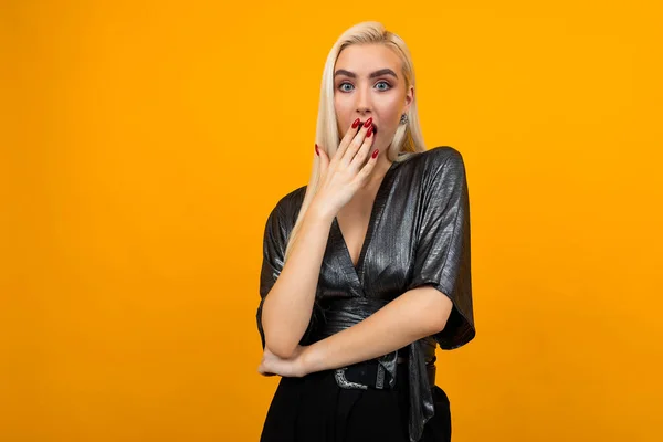 Európai szőke lány modell meglepett eltakarta a száját a kezét egy sárga háttér másolási hely — Stock Fotó