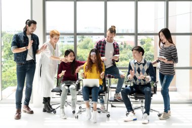 Çeşitli İnsanlar Ekibi gülümseyerek modern ofiste dizüstü bilgisayarla çalışmaktan heyecan duyuyorlar. Yaratıcı çok ırklı ya da çeşitli takım çalışması mutlu olmak, eğlenmek ve başarı projesiyle meşgul olmak.