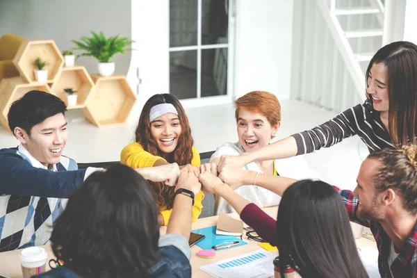 Çok ırklı genç takım modern ofiste birlik ve takım çalışması olarak el ele tutuşuyor. Çeşitli gruplar birliği ya da arkadaşlar bir araya gelir konsepti. Başlangıçta yumuşak tonda takım oluşturma.