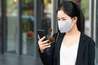 Sağlıklı yüz izi olan Asyalı bir kadın akıllı cep telefonu kullanarak Corona virüsünü koruyor. Coronavirus salgını 2019 (COVID-19) adlı koronavirüs salgını tüm dünyaya yayılmıştır..