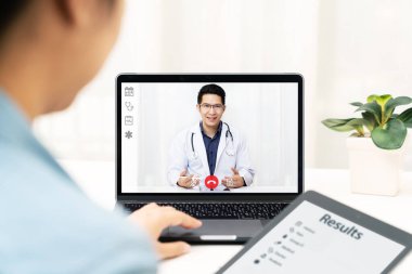 İnternetteki Asyalı doktor görüntülü konferans görüşmesi tıbbi koronavirüsle uzaktan yakından ilgili. İnternetteki sağlık hizmetleri dijital teknoloji hizmeti, danışmanlık ve röportaj uygulaması.