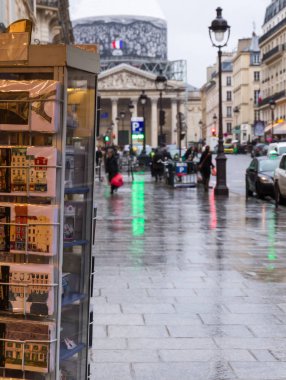 Şehrin turistik manzaraya: Paris Pantheon Hediyelik eşya ile yakınındaki alışveriş ön plan ve bulanık Pantheon, sokak, kartpostal ile bina, arabalar ve yapılar bir arka plan olarak.