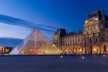Asıl Simgesel Yapı ve Paris, Fransa'nın turistik spot: Louvre Müzesi (müze du Louvre) ve geç akşam arka plan olarak mavi gökyüzü ile piramit.