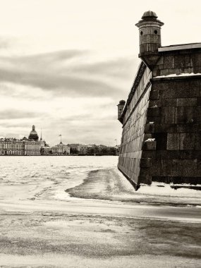 St Petersburg, Rusya'nın işareti: Peter ve Paul kale duvarı kış günü, Neva Nehri'nde buz, gökyüzü bulutlar ve arka plan olarak şehrin tarihi merkezi ile. Retro siyah ve beyaz fotoğraf.