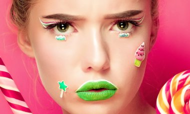 Güzel genç kadın ellerini şeker geniş gülümsüyor tutar.