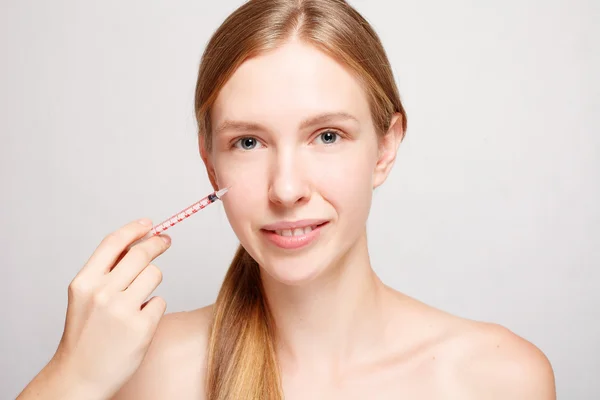 Привлекательная женщина пластическая хирургия со шприцем на лице — стоковое фото