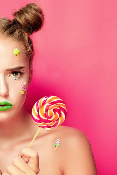 Hermosa joven mujer sostiene en las manos dulces sonriendo ampliamente . — Foto de Stock