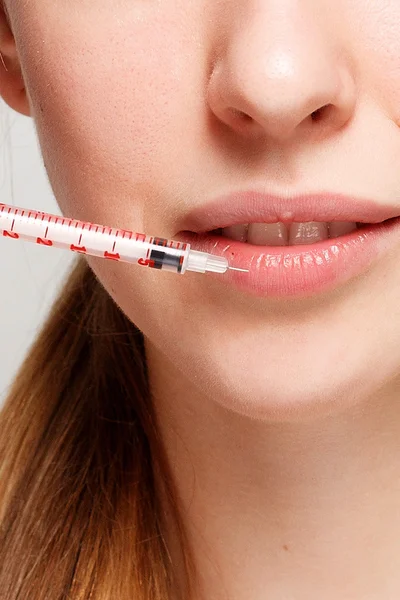 Attractive woman plastic surgery with syringe in her face — Stock Photo, Image