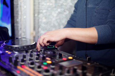 DJ partideki gece kulübünde şarkıyı karıştırıyor.