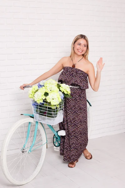 Young girl with vintage bicycle and flowers — Stock Photo, Image