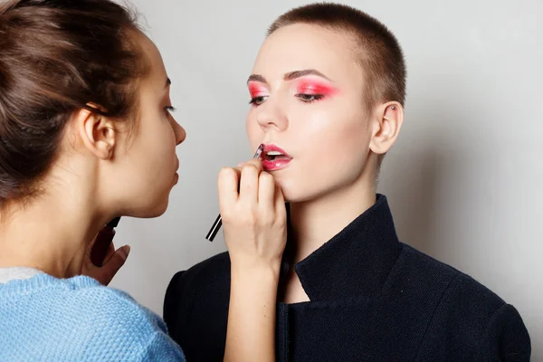 Maquiagem artista fazendo profissional jovem mulher — Fotografia de Stock