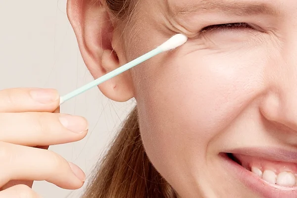 Gelukkig mooie jonge vrouw, schoonmaken van de huid door het wattenstaafje. — Stockfoto