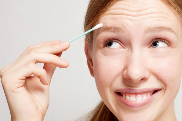 Gelukkig mooie jonge vrouw, schoonmaken van de huid door het wattenstaafje. — Stockfoto