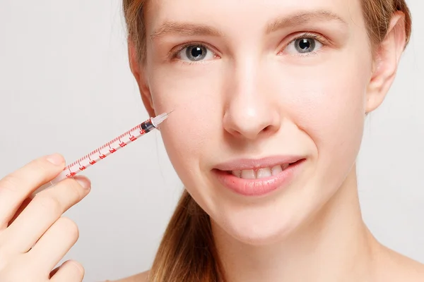 Attractive woman plastic surgery with syringe in her face — Stock Photo, Image