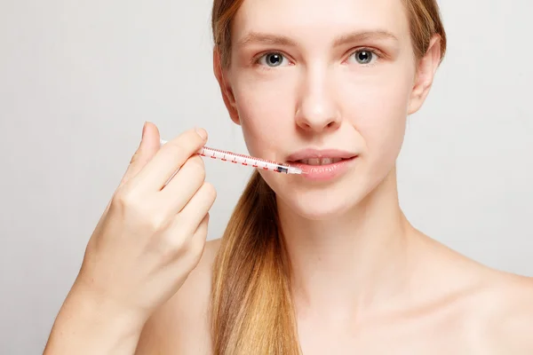 Привлекательная женщина пластическая хирургия со шприцем на лице — стоковое фото