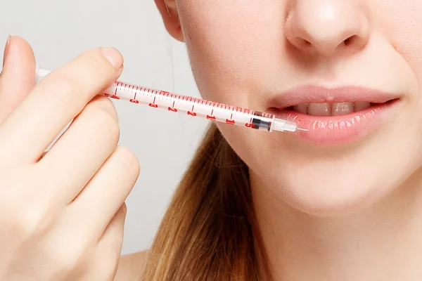 Attractive woman plastic surgery with syringe in her face — Stock Photo, Image